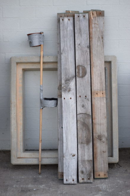 Drink holder stored against wall with wood planks
